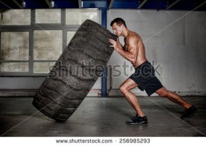 stock-photo-crossfit-training-man-flipping-tire-256985293